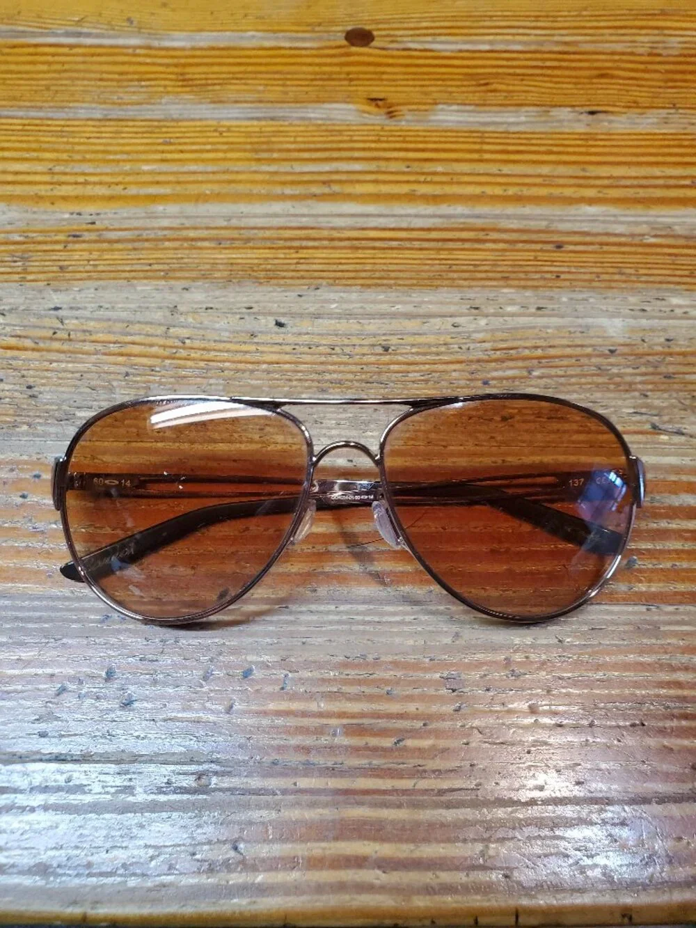 Oakley Caveat aviator sunglasses featuring a rose gold metal frame and warm brow